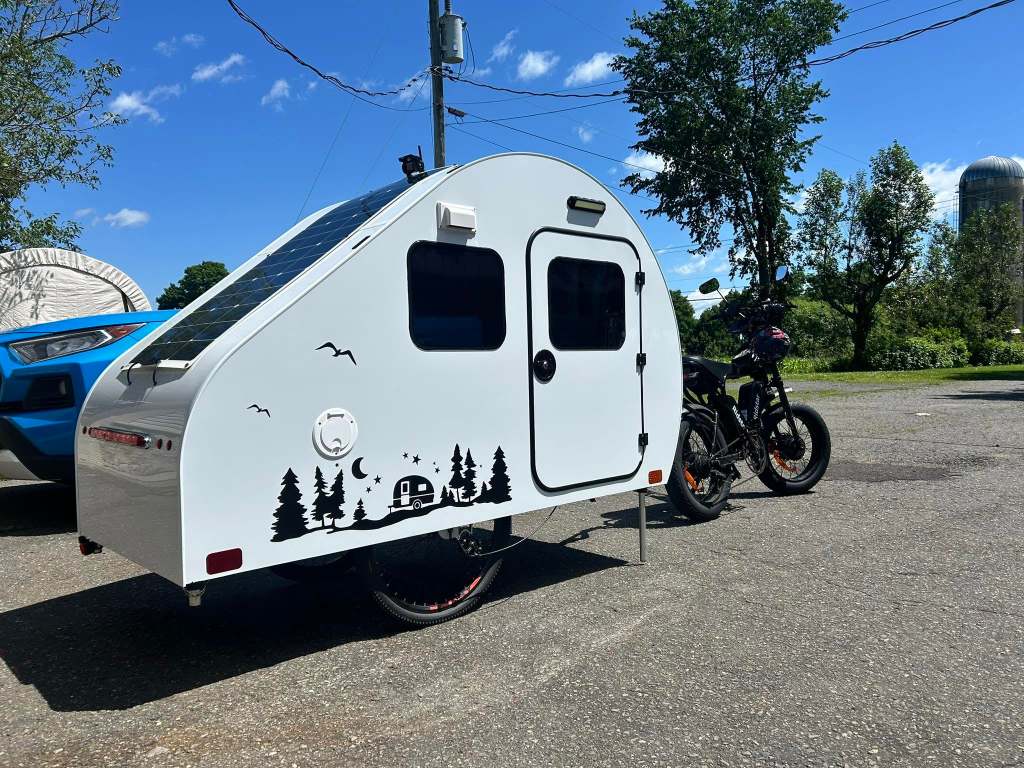 La roulotte est tirée par le vélo électrique de M. Tremblay. / Tirée de Facebook